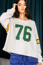 White raglan sleeve sweatshirt with green and yellow '76' graphic and sleeve stripes.