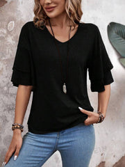 Black jersey tee with tiered short sleeves and V-neck, styled with jeans and necklace.