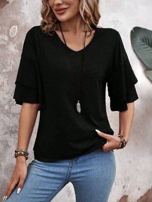 Black jersey tee with tiered short sleeves and V-neck, styled with jeans and necklace.