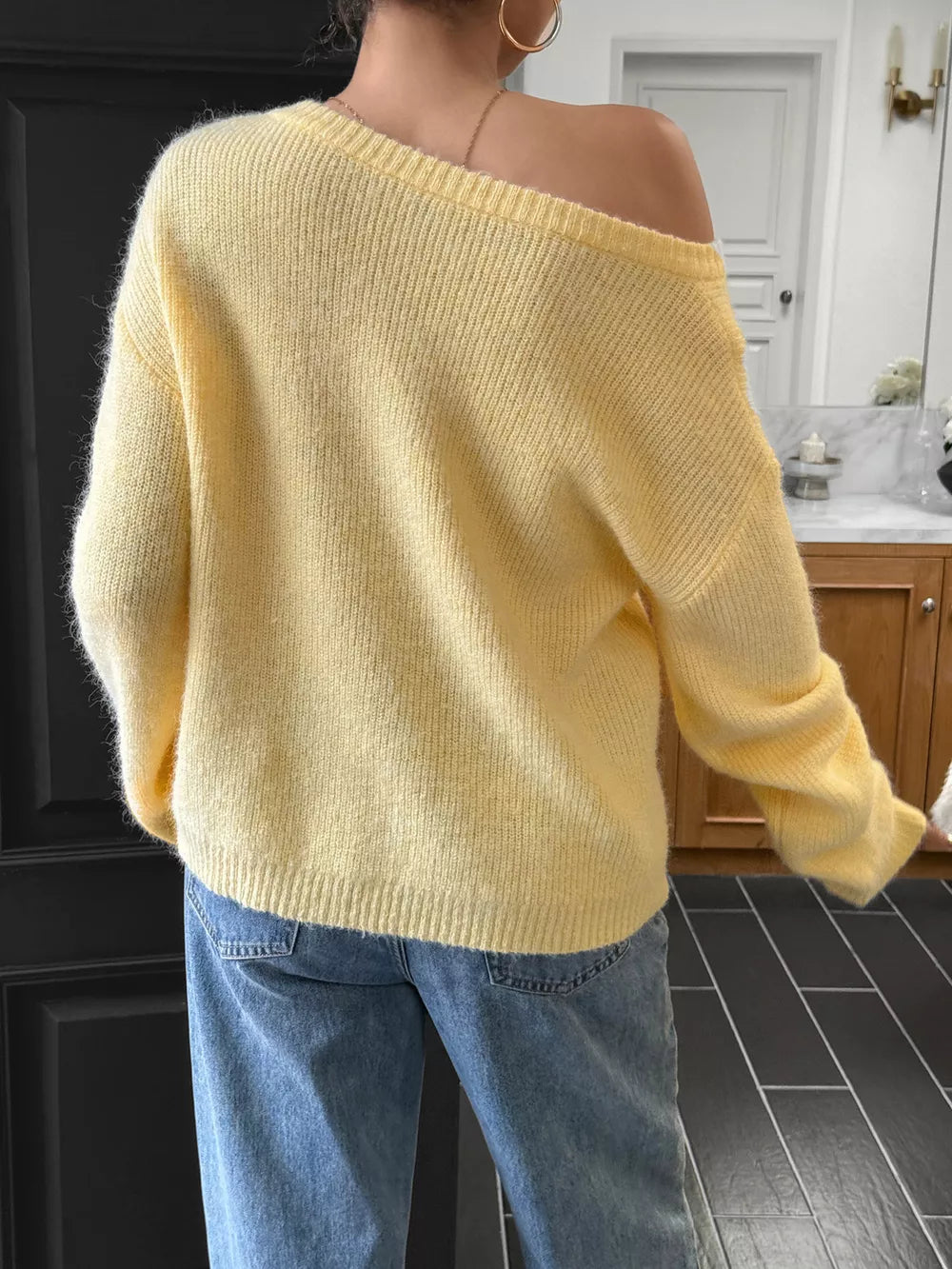Pastel yellow ribbed knit one-shoulder sweater with long sleeves.