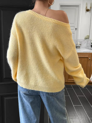Pastel yellow ribbed knit one-shoulder sweater with long sleeves.