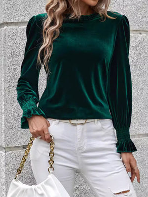 Dark green velvet blouse with blouson sleeves and ruffled cuffs.