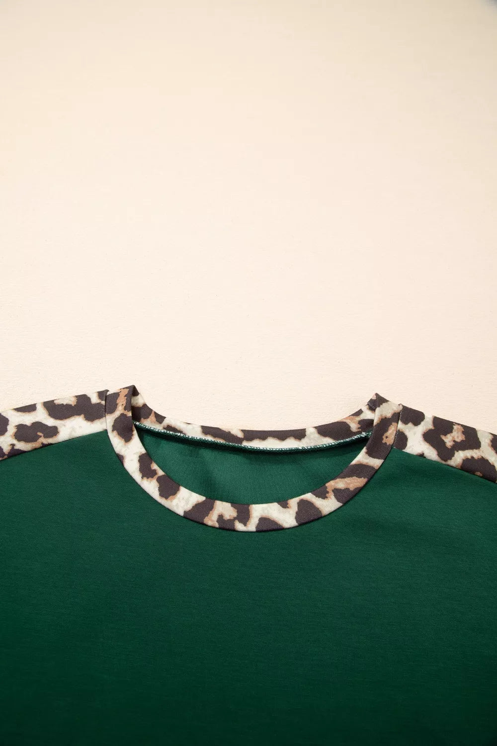 Green polyester tee with leopard print raglan sleeves and neckline detail.
