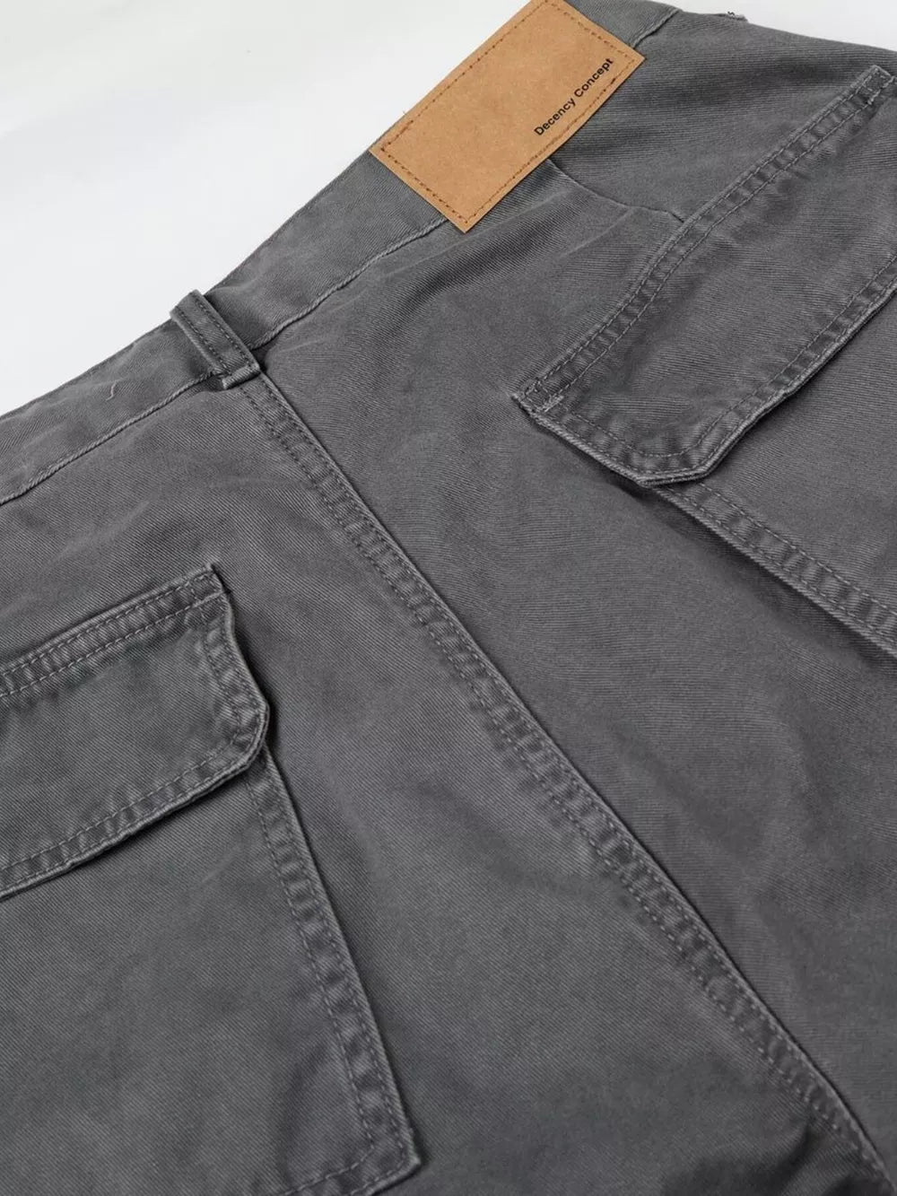 Relaxed fit grey cotton cargo capris with button closure and multiple pockets.