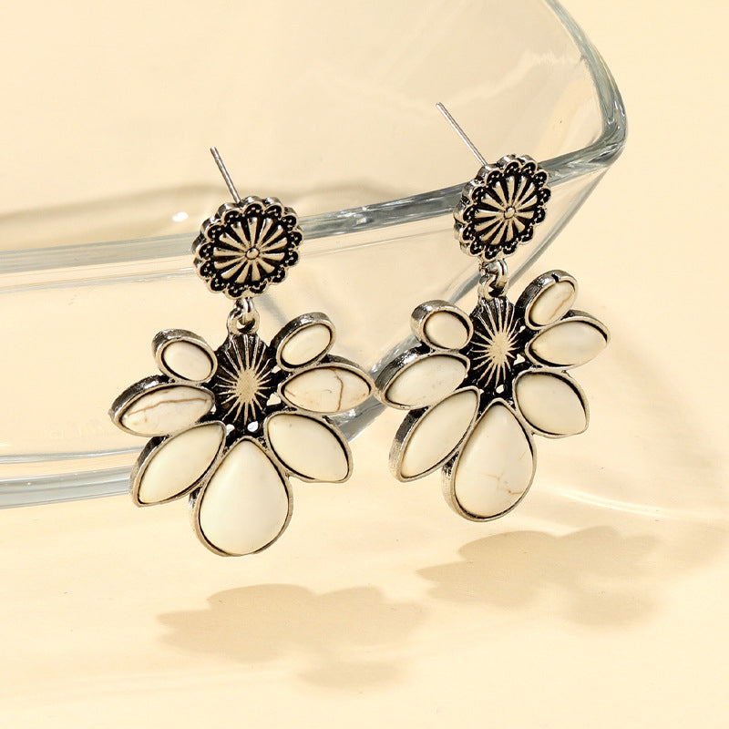 White petal drop earrings with silver alloy floral accents and a sunburst detail.