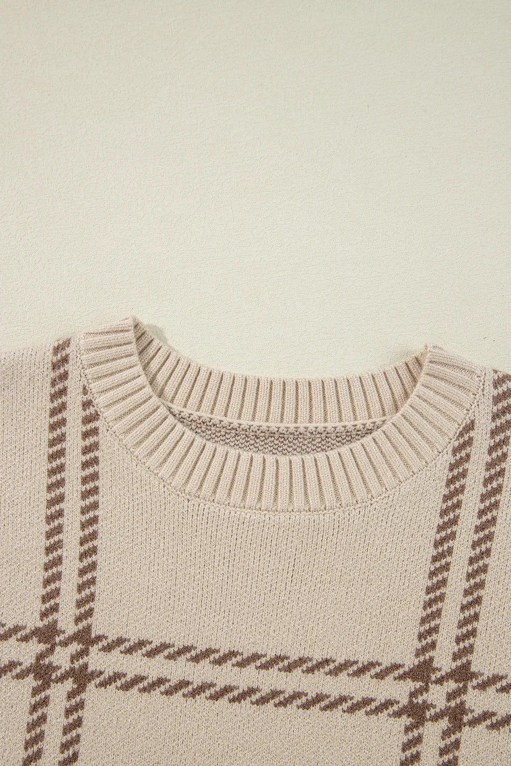 Tan crewneck knit pullover sweater with a brown gridline pattern and ribbed neckline.