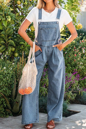 Denim wide-leg jumpsuit with pleats and buttoned sides, styled with a white tee.