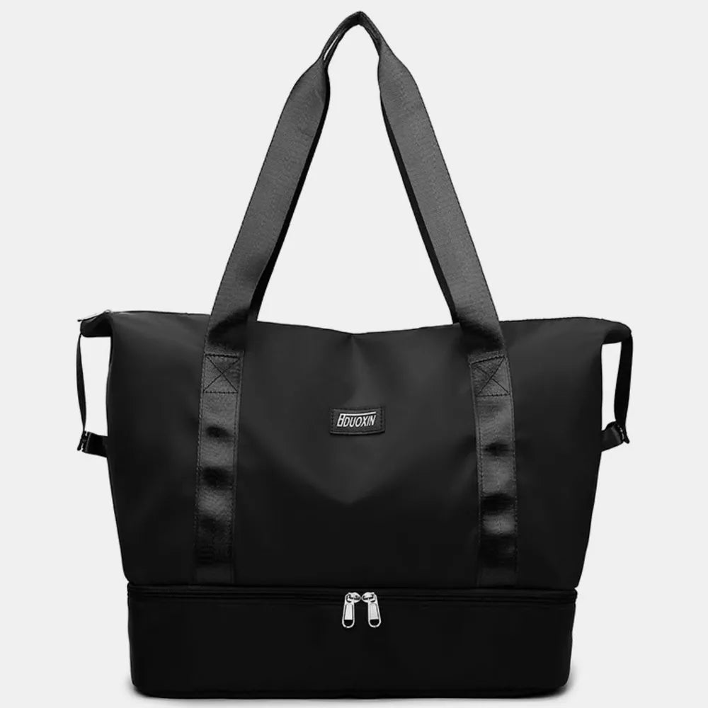 Black dual-compartment travel tote with metallic trim and dual zippers on bottom compartment.