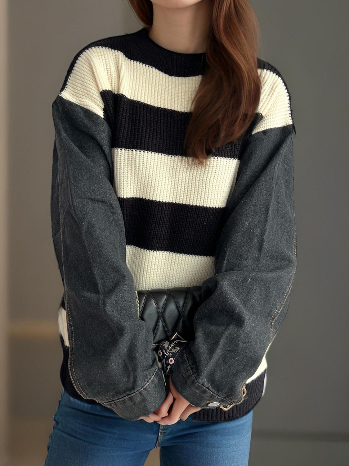 Striped knit sweater with black denim sleeves and crew neck.