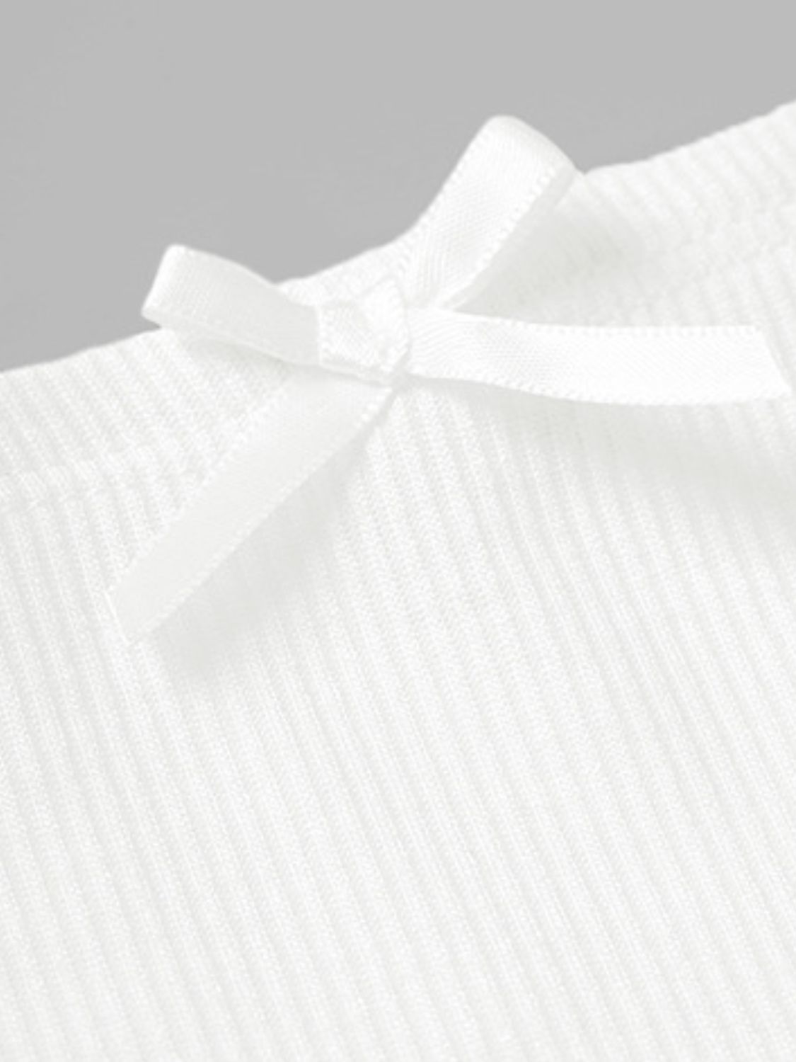White ribbed mini skirt with a small bow detail.