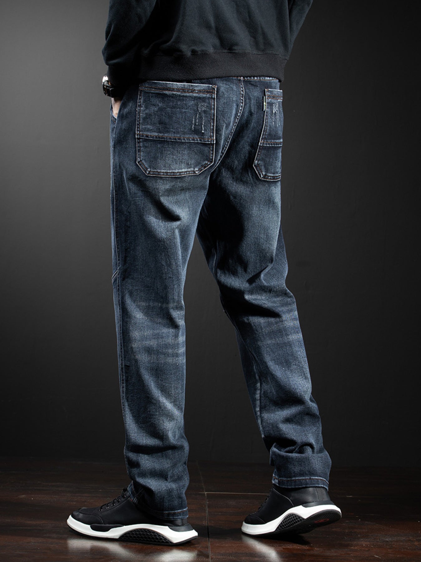 Men's dark wash loose fit cotton jeans with distressed details and drawstring waist.