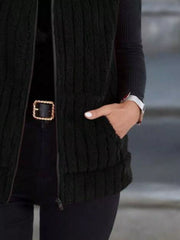 Black fleece zip-up vest with pockets and ribbed texture.