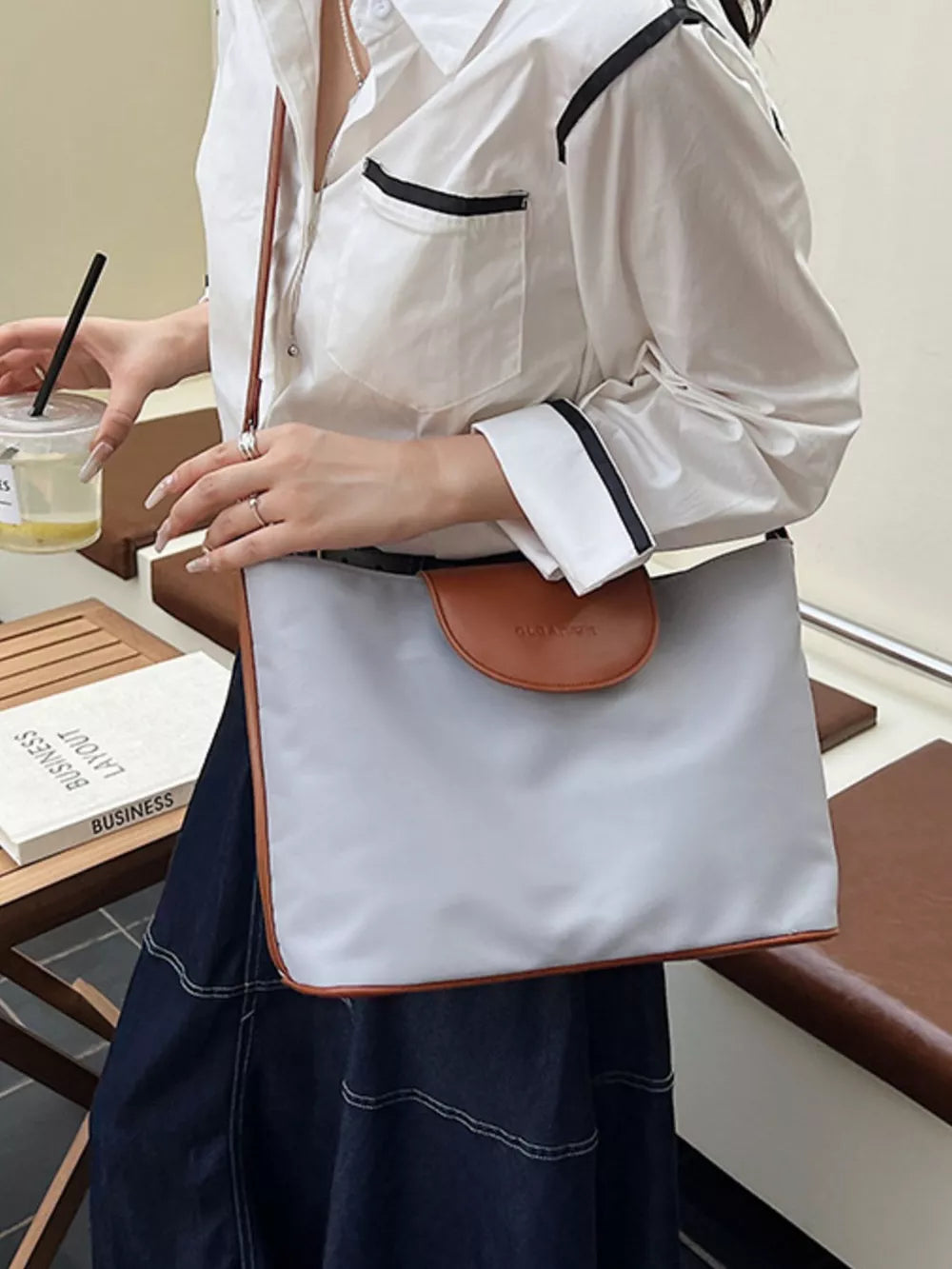 Chic canvas hobo crossbody bag in gray with brown trim and flap detail.