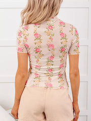 Sheer mesh floral blouse with short ruffled sleeves and mock neck.