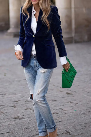 Navy velvet blazer with gold button detail and lapel, worn open over a white shirt.