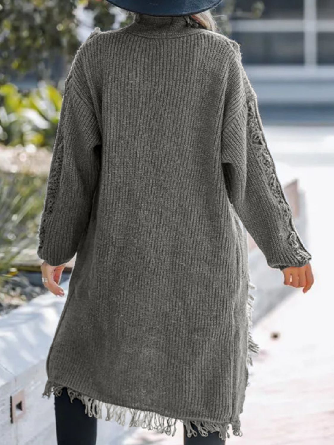 Gray acrylic maxi cardigan with textured knit, fringe hem, and openwork sleeves.