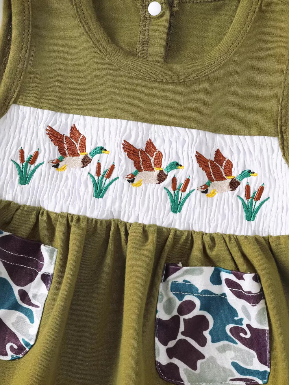 Olive green baby top with smocked white panel featuring embroidered ducks and reeds, and camo pockets.