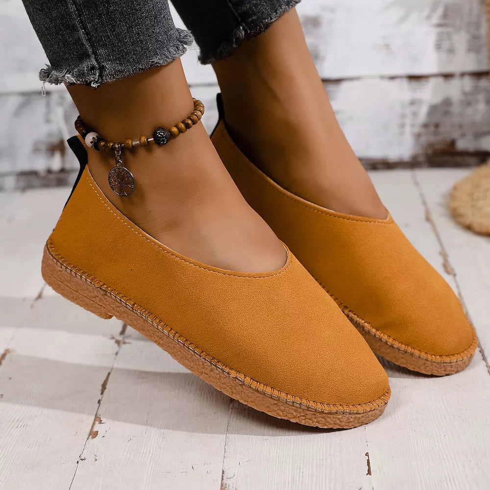 Yellow espadrille-inspired round toe slip-on flats with decorative ankle bracelet.