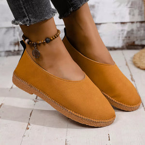 Yellow espadrille-inspired round toe slip-on flats with decorative ankle bracelet.