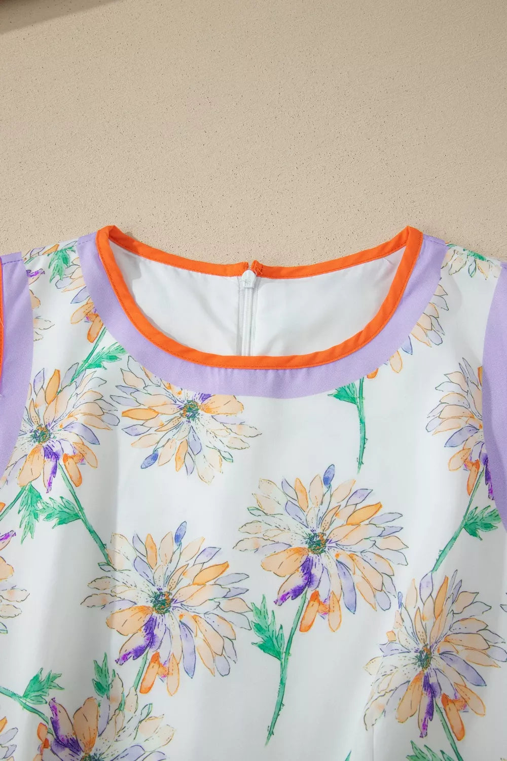 Sleeveless floral print dress with purple and orange trim and a zipper closure.