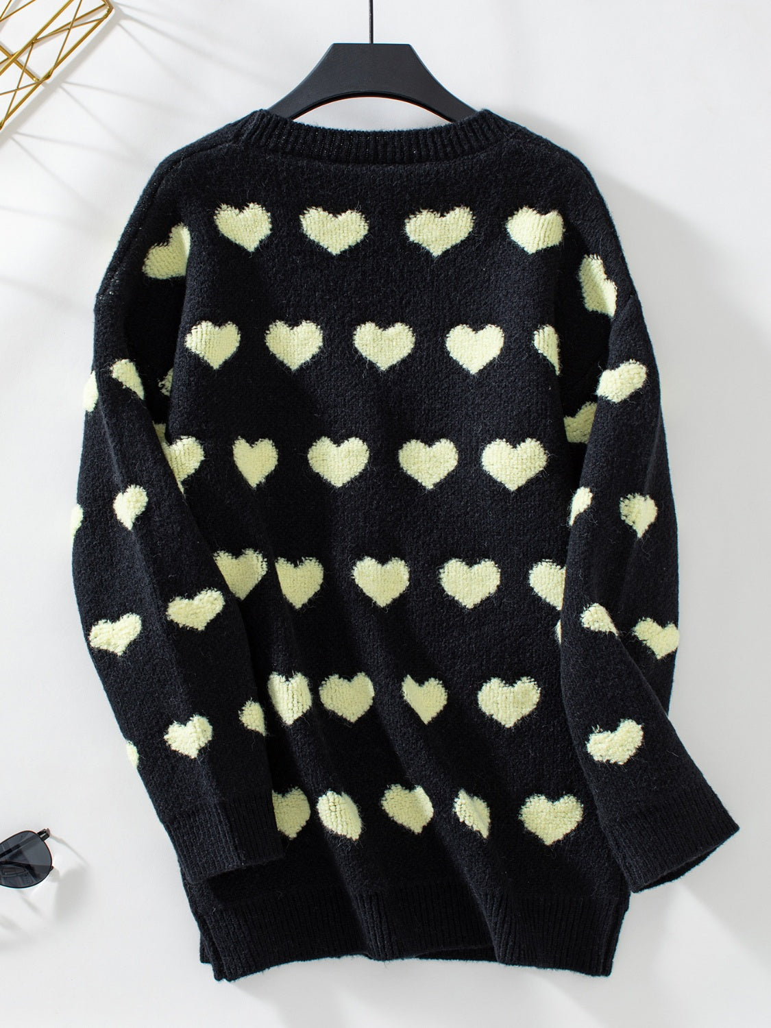 Black acrylic knit cardigan with allover light yellow hearts pattern, crew neck.