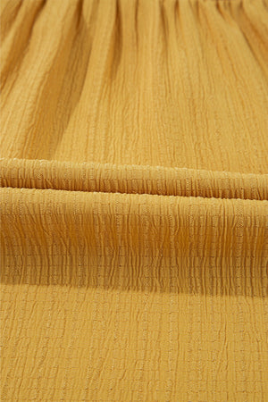 Mustard yellow textured blouse fabric with vertical ribbing detail.
