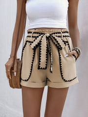Tan paperbag shorts with scalloped black trim and tie waist