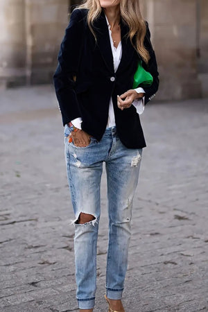 Navy velvet blazer with gold button detail worn with a white shirt and ripped jeans.