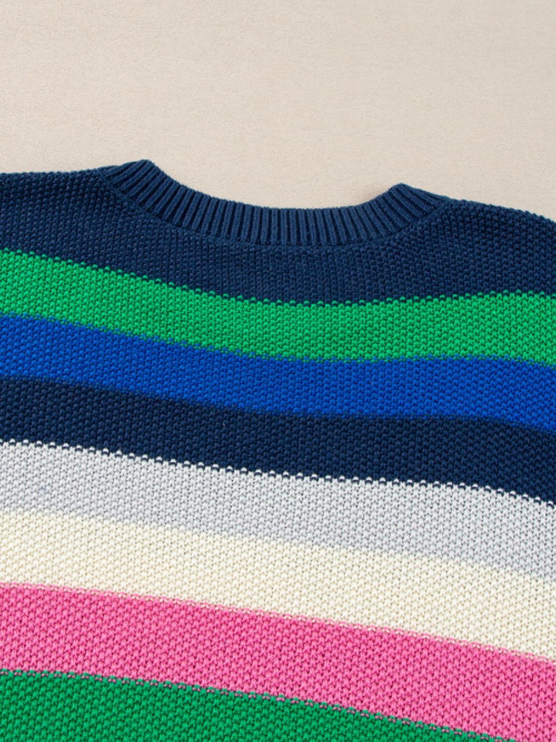 Chunky knit crewneck sweater with horizontal stripes in navy, green, blue, white, and pink.