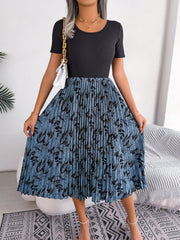 Botanical pleated midi dress in dark blue with black floral print, short sleeves, round neck.