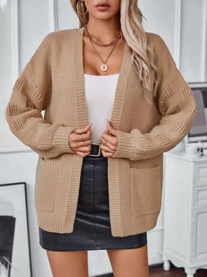 Chunky knit camel open-front cardigan with pockets and textured sleeves.