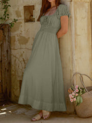 Olive green smocked waist maxi dress with puff sleeves and square neckline.