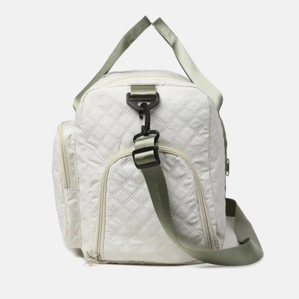 White quilted duffel bag with olive green strap and accents, side zip pockets.