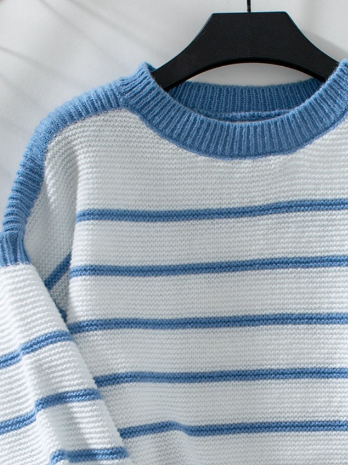 Blue and white striped knit sweater with wide sleeves and crew neck.