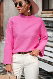 Pink ribbed mock neck sweater with volume sleeves and a relaxed fit.