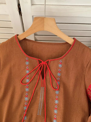 Brown tie neck shirt with folk embroidery and red trim