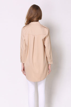 Tan trench coat with shoulder detailing and buttoned cuffs, back view