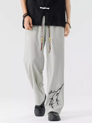 Light gray men's wide-leg sweatpants with embroidered branch detail on the leg.