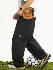 Black convertible cargo pants with zip-off legs and side logo detail