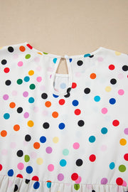 White blouse with rainbow polka dots, keyhole neckline, and tiered hem.