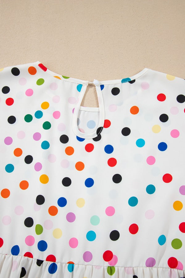 White blouse with rainbow polka dots, keyhole neckline, and tiered hem.