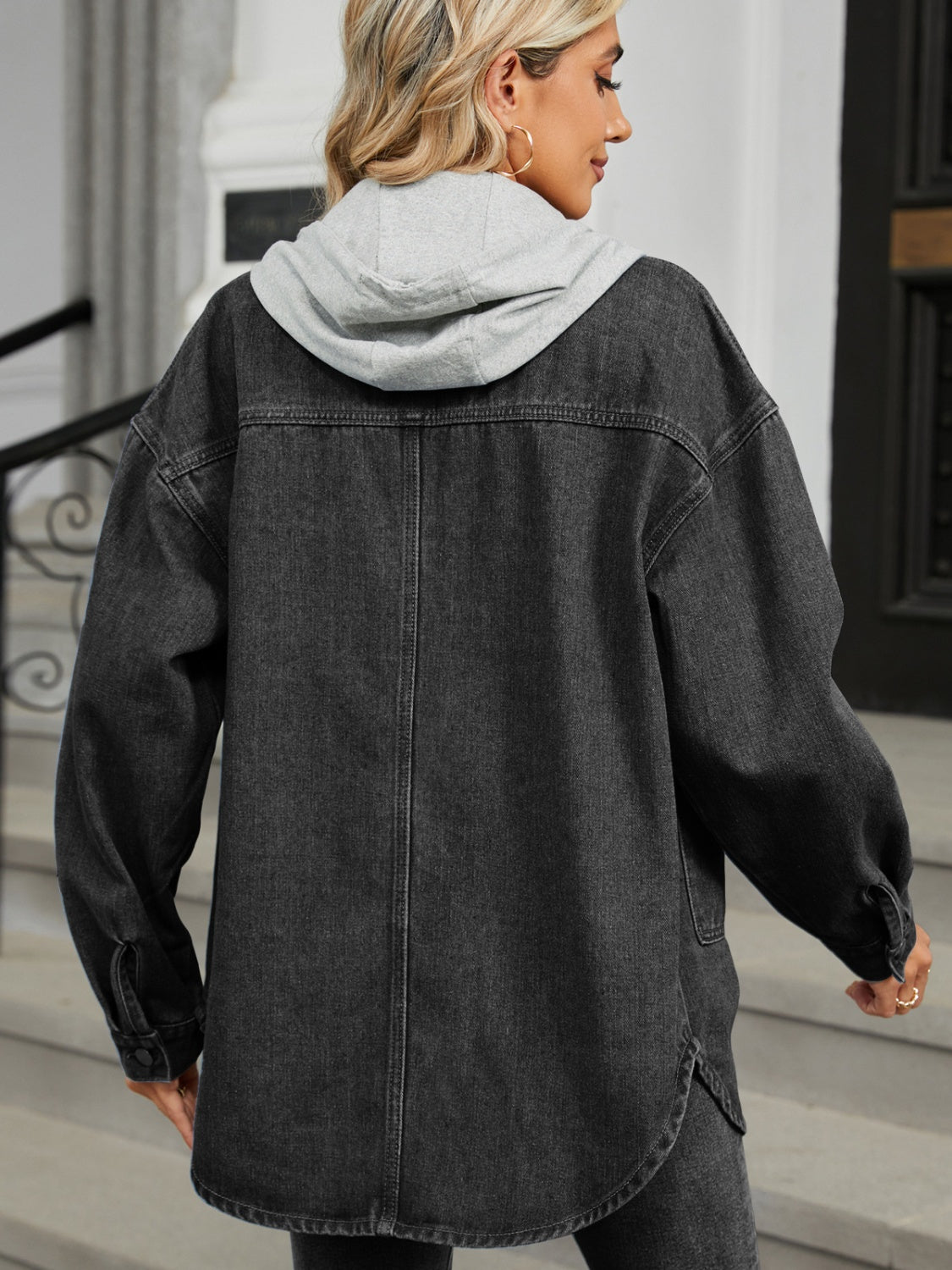 Black oversized denim jacket with hood and buttoned cuffs, casual trucker style.
