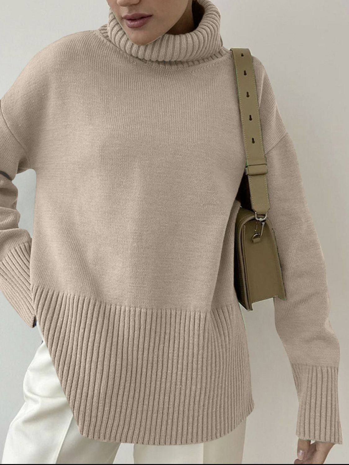 Khaki ribbed turtleneck sweater with flared sleeves and a textured hem.