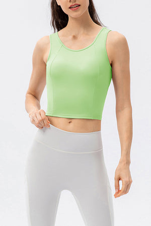 Green active crop top with scoop neck and sculpted seams, sleeveless.