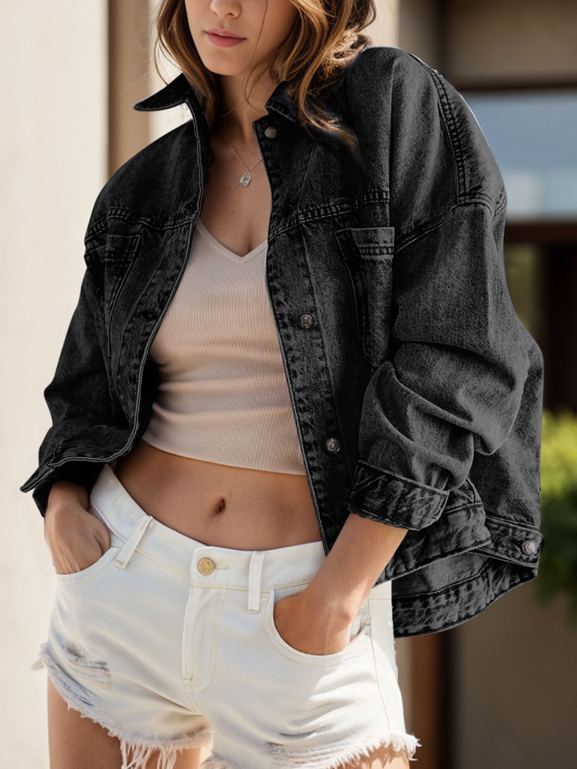 Oversized washed black denim trucker jacket with button front and chest pockets.