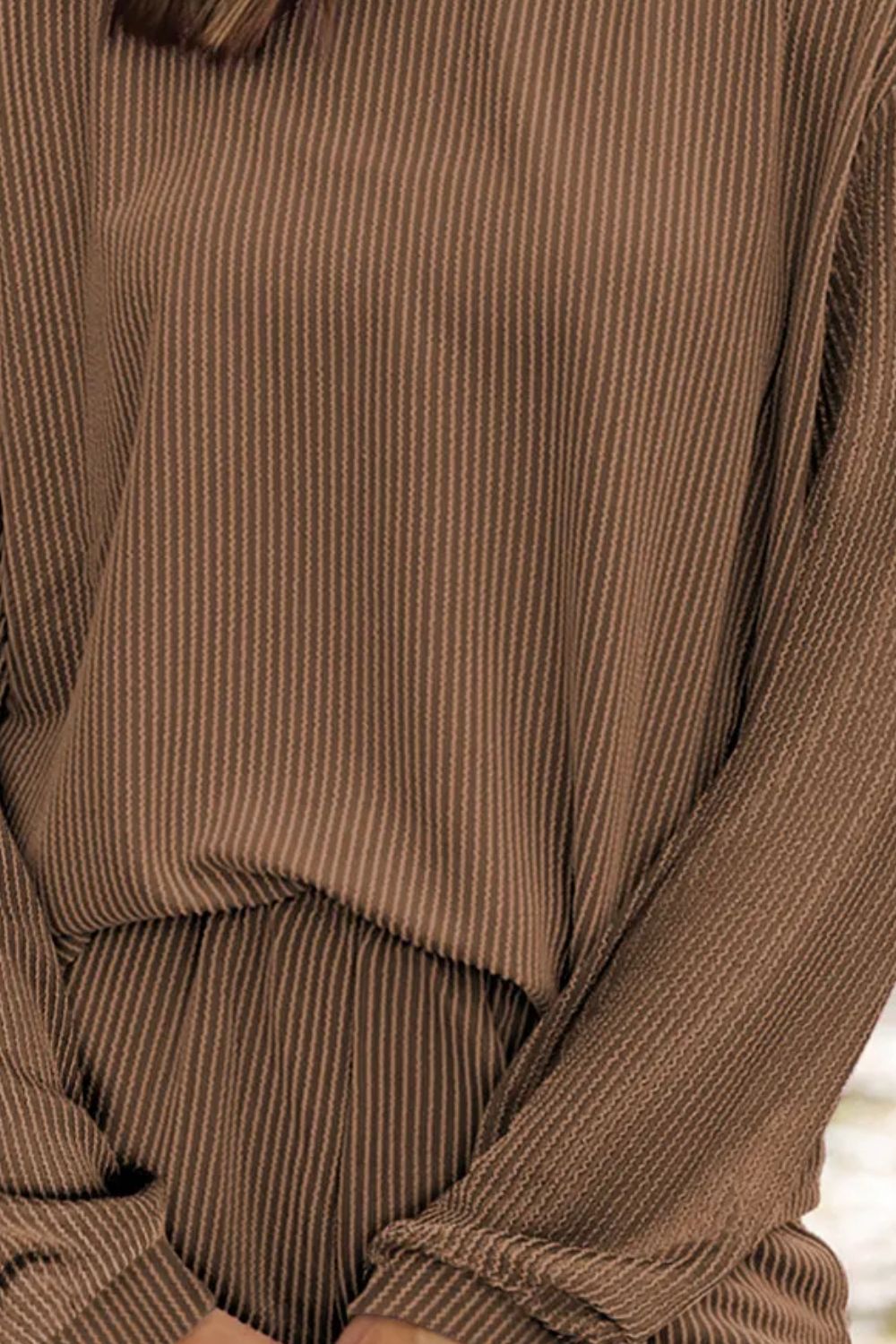 Brown ribbed knit matching set with vertical stripes, long sleeves, and cinched waist detail.