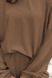 Brown ribbed knit matching set with vertical stripes, long sleeves, and cinched waist detail.