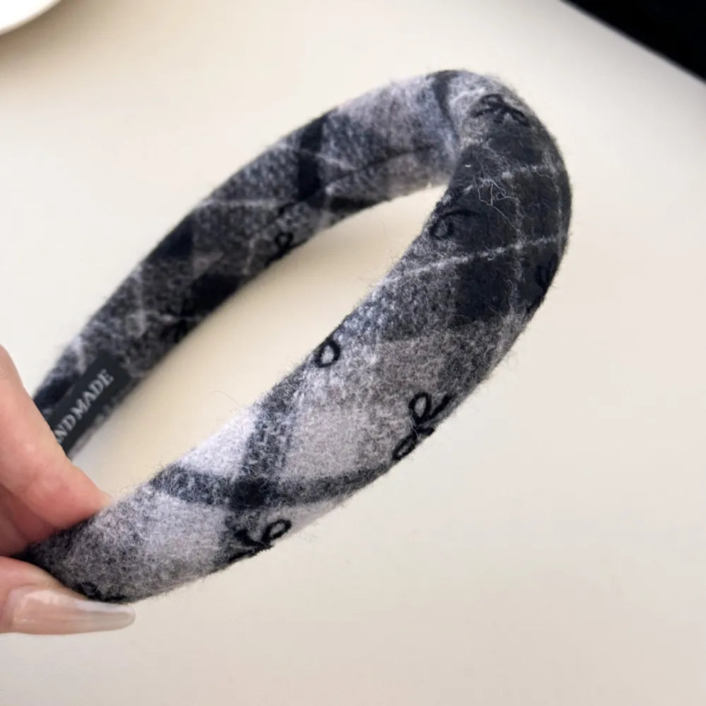 Embroidered plaid padded headband in dark gray with subtle black embroidery.