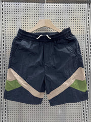 Men's boxer shorts in dark blue with beige and green color block accents.