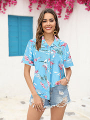 Sky blue tropical print camp collar shirt with pink flowers and flamingos, short sleeves.